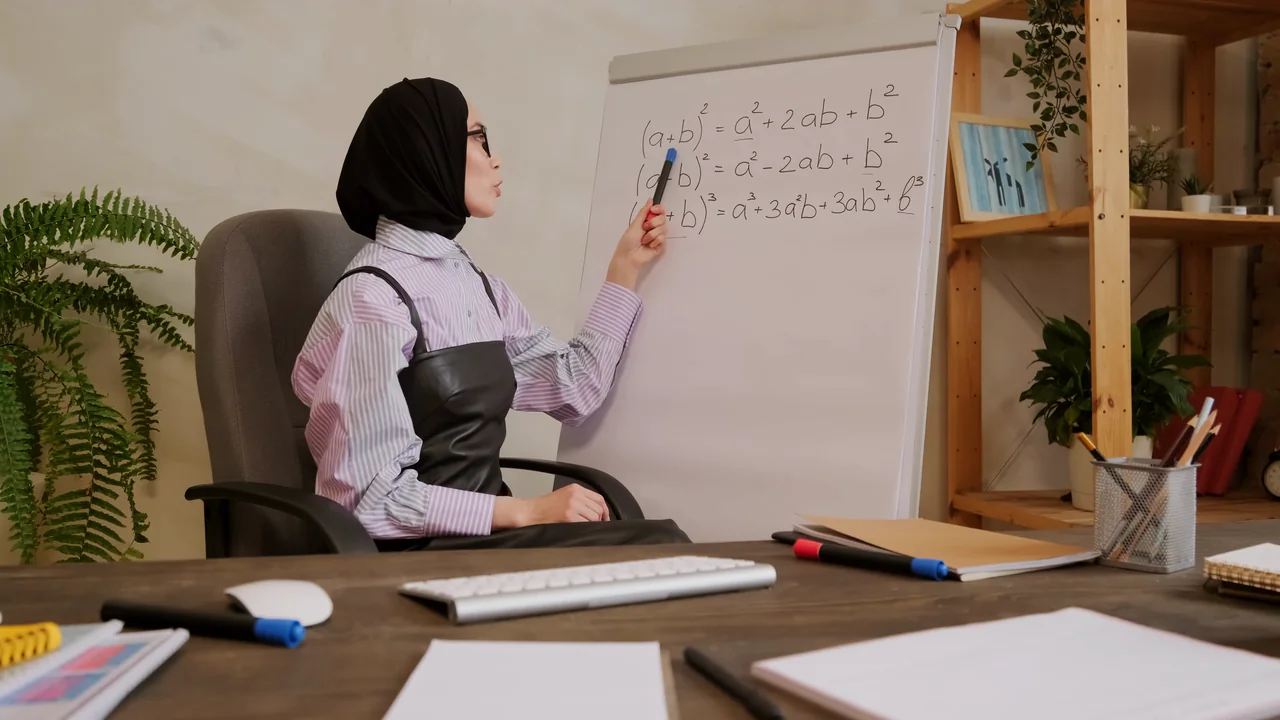 A teacher explaining at a whiteboard during an online lesson